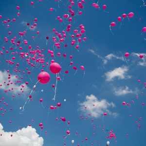 Viele rosafarbene Luftballons fliegen in den Himmel