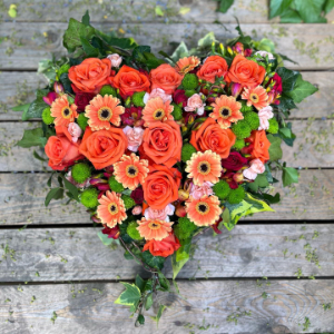 Trauergesteck in Herzform mit orangen Rosen und Gerbera